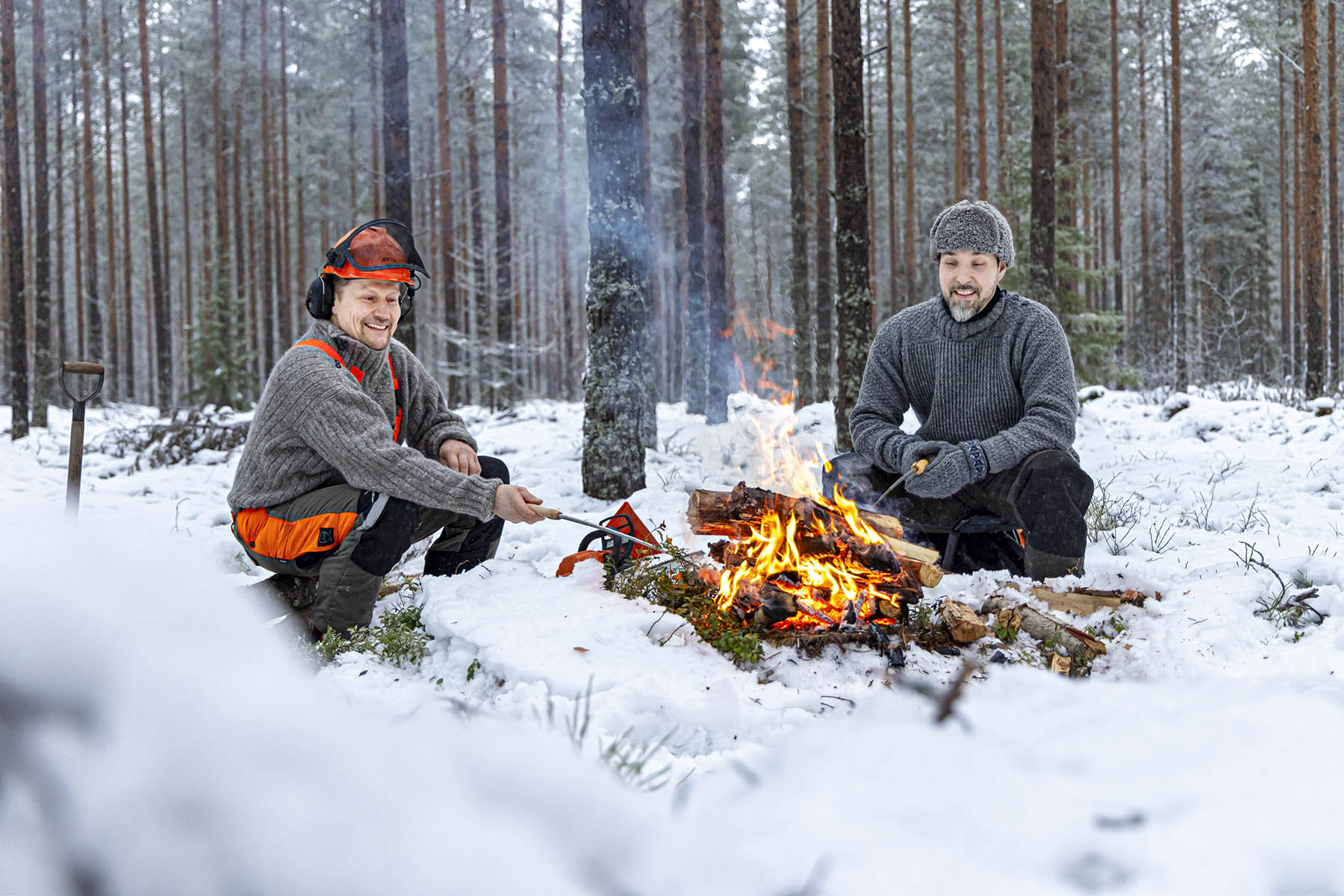 Nuotiomakkara maistuu Jouni Karppiselle ja Ossi Keräselle metsähommien tauolla.