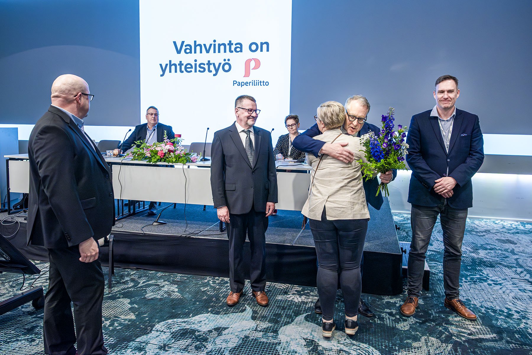Järjestöasiantuntija Annika Maunula ja liittosihteeri Juhani Siira (vas.) onnittelevat valittuja. Jouko Aitonurmi valittiin valtuuston puheenjohtajaksi, Petri Vanhala liiton puheenjohtajaksi ja Ville Nevala valtuuston varapuheenjohtajaksi. Takana istuvat Esa Pajunen ja Anu Valtonen. Paperi­liiton 24. liittokokous pidettiin Helsingissä 11.–12.6.2025.