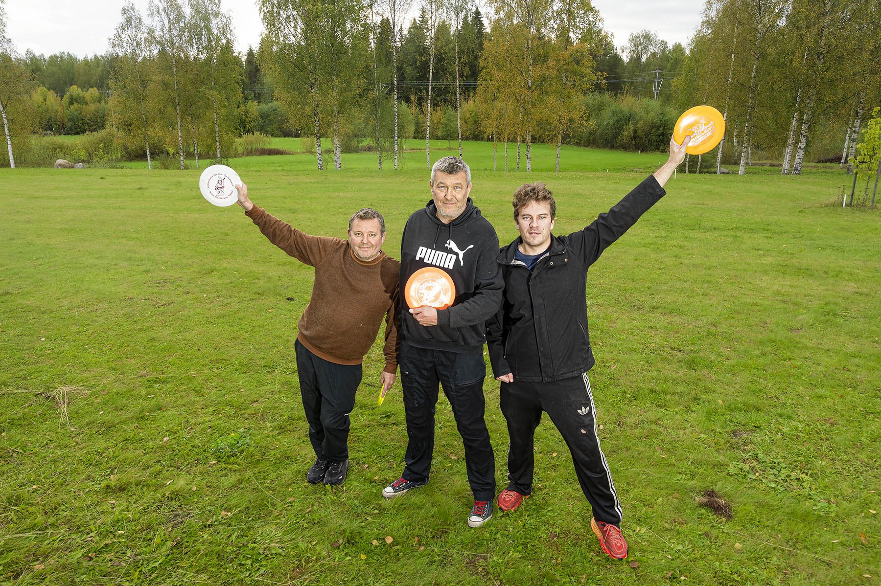 Jippii! Frisbeegolfkeskuksen väylät on tehty, ja kohta alkaa kisailu. Kuvassa venyttelevät hankkeen isä Jarno Kolu (vas.), Sami Väisänen ja Teemu Raatikainen.
