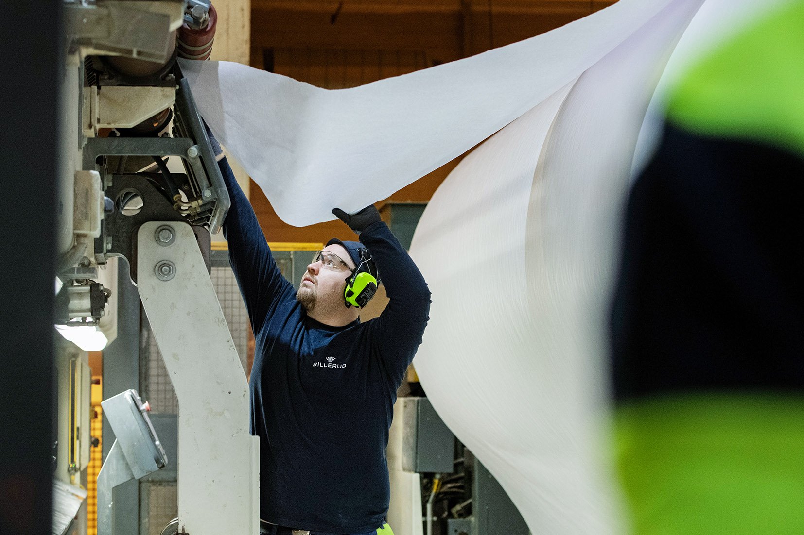 Elämää helpottava työaikamuoto. Jälkikäsittelijä Iiro Vilkas ei voisi kuvitella tekevänsä muuta kuin 12-tuntista vuoro­järjestelmää.
Taneli Miettinen vie rullan päätä leikkurin telojen väliin
Pituusleikkurinhoitaja Sebastian Pesola ja Taneli Miettinen vetävät päätä leikkurille.
 Iiro Vilkas siirtää tampuurin leikkurille. 