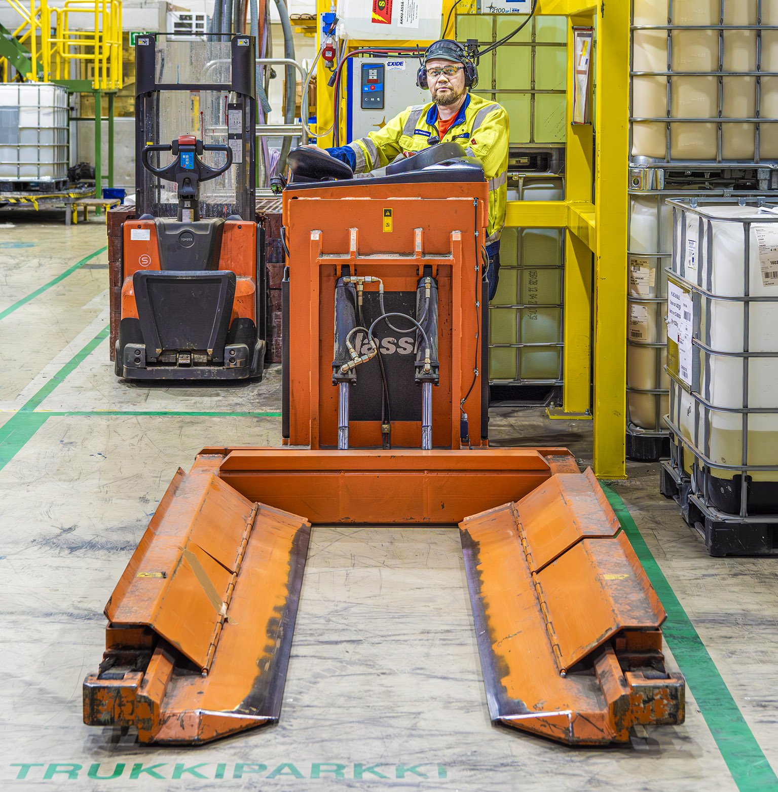 Sähkötrukin latauspaikan sijaintia ja turvallisuustoimia Valkeakosken Walkilla esittelivät työsuojeluvaltuutettu Jukka Lumijärvi, Juha-Pekka Mäkelä ja Tero Heinonen. 
Tuotantosalissa sijaitseva latauspaikka on merkitty lattiaan. Keltaisten pilarien paikalle pystytetään paloturvallisuutta lisäävät seinäkkeet.