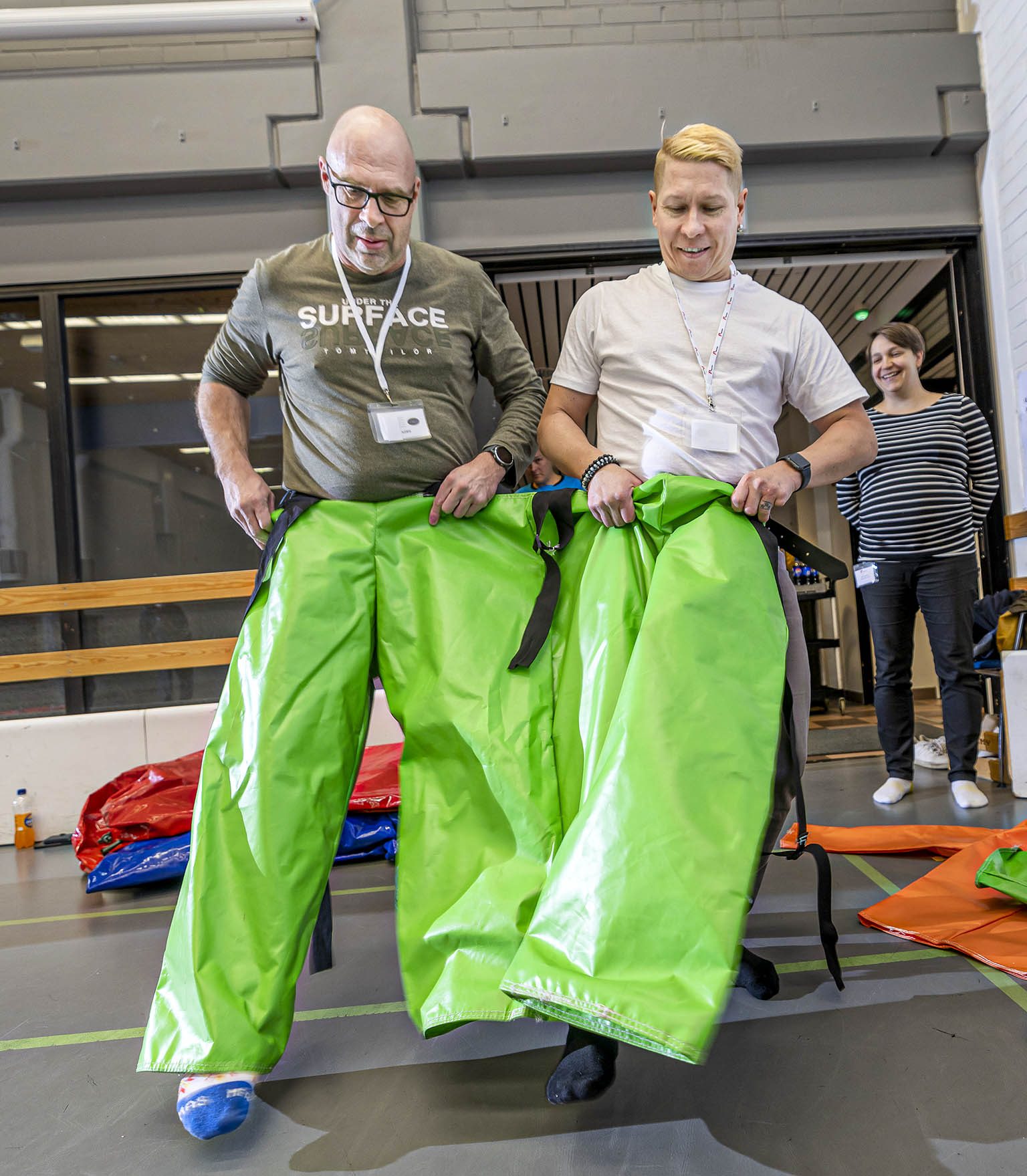  Tiimityötä. Satu Lääperi ohjeistaa Janne Hämäläistä ja Janne Lindströmiä.
Kolmijalka­juoksuun. Juha-Matti Jokinen ja Jyrki Nousiai­­nen valmiina lähtöön toinen jalka samassa lahkeessa.
Hyvinvointi­päivän toiminnallinen osuus yllätti Heidi Vainion Kaukopäästä, mutta positiivisesti. Pomppupötkylän selässä tiimiläisiä Kuopiosta, Kauttualta ja Heinolasta.
Yli maaliviivan. Kari Arvila Kotkasta, Elina Löppönen Kauttualta, Kati Ukkola Inkeroisista ja Mikko Virkkula Porista jalat hapoilla.